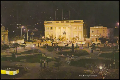Foto noturna da Praça Teodomiro Santiago, Clube Itajubense e Bar Acadêmico