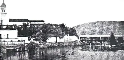 O rio Sapucaí, vendo-se a ponte de madeira, com cobertura de zinco, inaugurada em 7 de dezembro de 1883, que existiu até que se contruísse, 45 anos depois, a ponte “Randolfo Paiva”