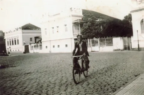 Rapaz de bicicleta na praça Wenceslau Brás